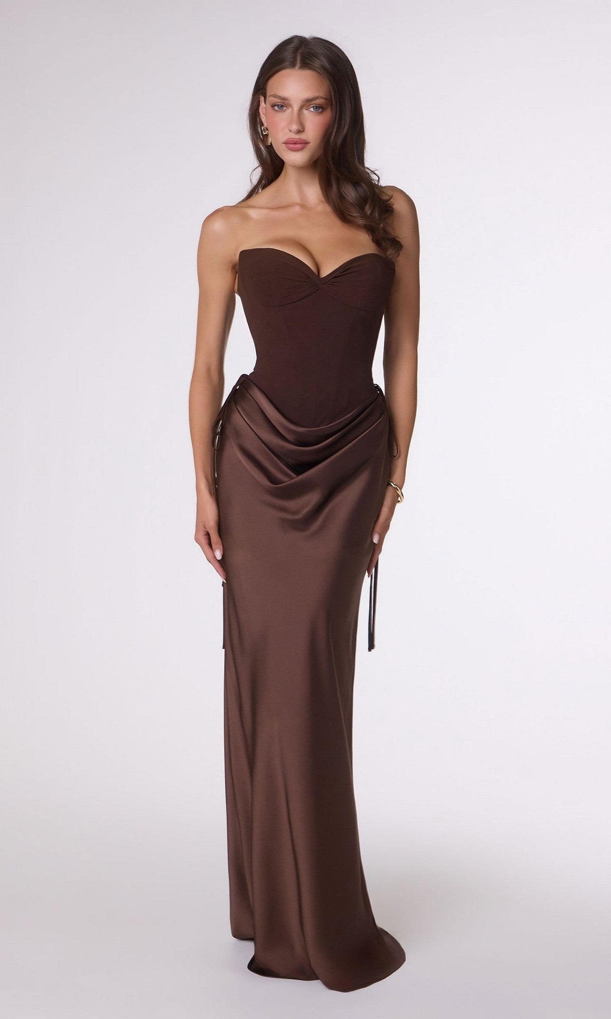 Woman stands facing forward, wearing the Amoris T747 long prom dress in Espresso—a strapless satin gown with a fitted bodice and draped skirt—against a plain light background.